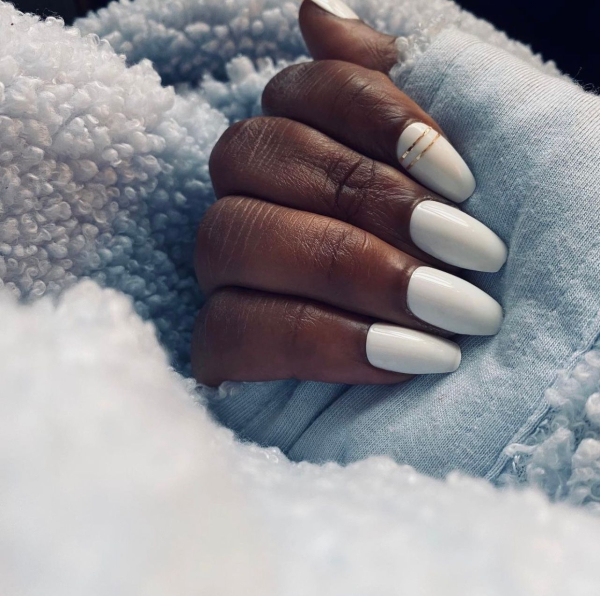 Shot of hand with baby blue shirt on blue blanket with white nails — wedding nail ideas.